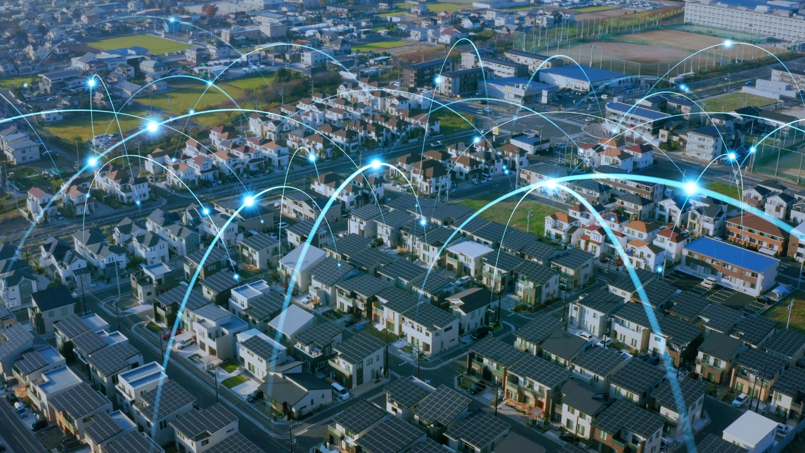 Vista aérea de viviendas y edificios conectados por una red luminosa azul